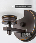 Close-up of Phoebe 8 Inch Modern Wall Sconce with Frosted Seeded Glass Cylinder Shade in Oil Rubbed Bronze Finish.