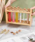 Wooden Test Tube Rack Kit With 12 Hole Holder And 12 Glass Tubes With Cork Stoppers 2 Tube Brushes And Corks Ten Point Four By Three Point Nine By Six Point Seven Inch Lab Gear For Chemistry Experiments And Science Class displayed on a table