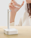 Woman using Desktop Water Bottle Dispenser with 7 Stage Adjustable Pump and Anti Slip Base for Easy Hydration at home