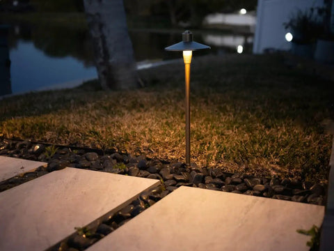 G2 12V Brass Path Light illuminating pathway in garden with warm white LED, night view of low voltage landscape lighting
