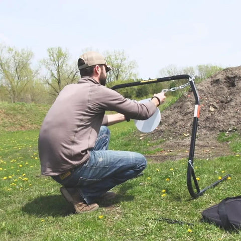 Person setting up Replacement Magnum Rifle Gong With AR550 Steel Construction for outdoor shooting range practice.