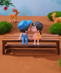 Two Pack Miniature Wooden Benches For Dollhouse Furniture And Fairy Garden Decor Realistic Retro Brown Wood Look Perfect Doll House Lawn Park And Garden Accessories Totally Cute Collectible Props featuring two figures sitting on a brown bench in a park setting with toy animals.