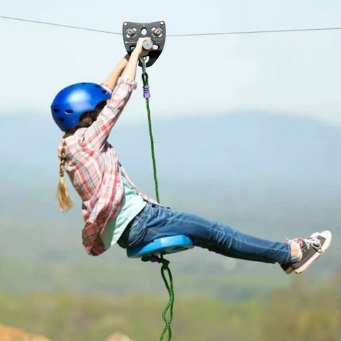 Child using Beefy Tandem Speed Double Pulley System For Zip Lines 45kN Break Load High Tensile Steel Alloy Fits 9 To 13 mm Cable outdoors.