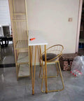 Rock Solid X Frame Steel Pipe Table Legs For Coffee Tables And Bars in a home setting with a white top and gold finish.