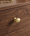 Top Shelf Champagne Bronze Cabinet Knobs With A Hammered Oval Dome And Soft Metallic Luster on wooden drawer.