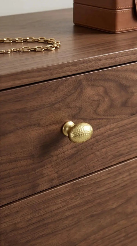 Top Shelf Champagne Bronze Cabinet Knobs With A Hammered Oval Dome And Soft Metallic Luster on wooden drawer.