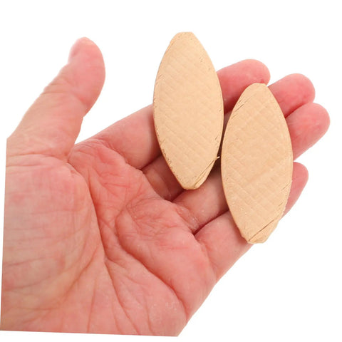 Two woodworking biscuits held in hand for solid joinery, part of Straight Shooting 100 Piece Woodworking Biscuit Slots.