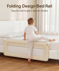 Child climbing on bed with Foldable Toddler Bed Rail Guard With Reinforced Anchor Safety System For King Twin Full And Queen Beds Khaki 59 Inches Long By 21.6 Inches High With Kid Friendly Soft Peach Skin Fabric And Removable Washable Cover attached, in a modern bedroom setting.