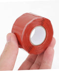 Hand holding red DIY Friendly Pipe Sealing Tape Self Adhesive Sealant For Leak Stop And Plumbing Repairs Flexible Waterproof Tape For Home Use
