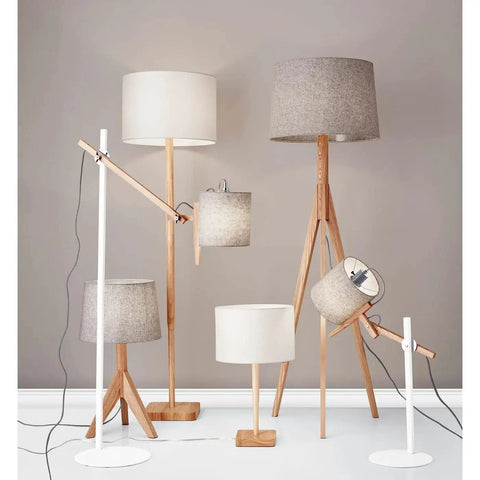 Collection of various lamps with natural wood bases and felt shades in a living space setting.