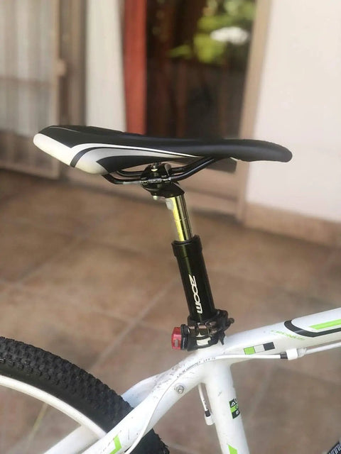 Close-up of Bike Suspension Seatpost Shock Absorber Damper Post For 27.2 30.9 31.6 Mm with black head on white bicycle.