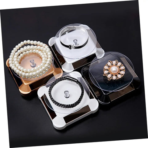 Solar Powered Rotating Jewelry Display Stand With Built In Kickstand showcasing pearl and decorative bracelets on sleek ABS risers.