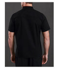 Back view of personalized chef coat custom embroidered name, black, heavy cotton, professional kitchen workwear for line cooks.