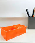 Orange plastic desk storage drawer box with tier compartments next to pens, for under desk organization large capacity desktop organizer