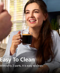 Woman enjoying coffee near Fully Automatic Espresso Machine With Built In Grinder And Milk Frother, visible on kitchen counter