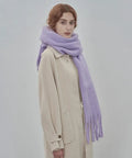 Woman wearing cozy large blanket wrap shawl for women, soft thick knit scarf neck warmer in pastel lavender, suitable for all seasons.