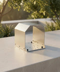 Heavy Duty Grey Foot Switch Guard Cover With Angled Hooded Shape And Textured Coating For Tight Machine Shop Spaces Durable Hardware Accessory on a table.