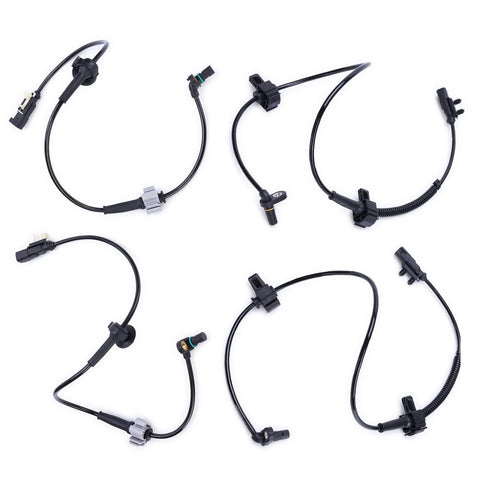 Set of four black ABS wheel speed sensors with wiring harnesses and connectors.