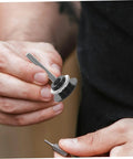 Close-up of hand holding Dope Push Button Hood Pin Latch Kit For Cars accessory, with black latch and threaded rod visible.
