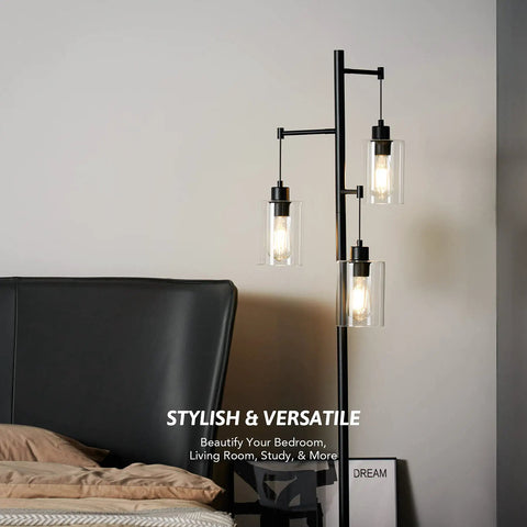 Black Floor Lamp With Three Glass Shade Branches Dope Industrial Tree Lamp For Living Room Or Office 64 Inch Tall Modern Farmhouse Style Includes Three 8W LED Edison Bulbs next to a bed.