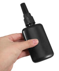 Hand holding Solid Black 50ml H Dpe Sealed Dropper Bottles Kit perfect for industrial glue dispensing and DIY craft projects.