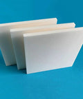 Three lab grade 99% alumina ceramic sheet insulators for high temperature substrates displayed on a blue surface.
