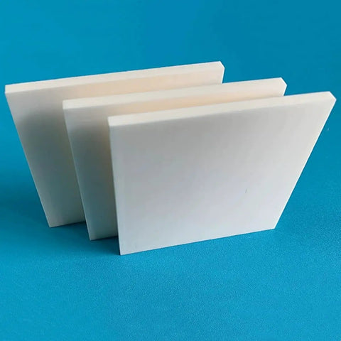 Three lab grade 99% alumina ceramic sheet insulators for high temperature substrates displayed on a blue surface.