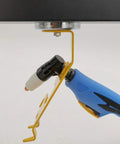 Side view of magnetic TIG torch holder with yellow bracket holding blue welding torch.