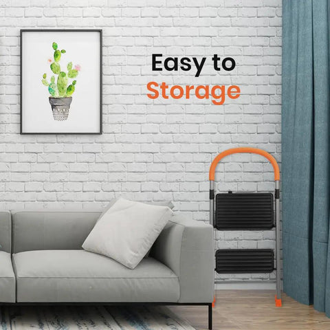 2 Step Folding Step Stool Ladder With 330Lb Heavy Duty Steel Frame next to a grey sofa and cactus picture in a living room