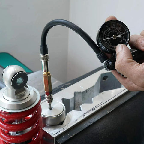 NICECNC nitrogen needle kit with gauge attached to a shock absorber; red coil spring visible
