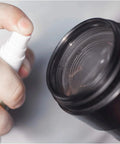 OptiSource Clear View lens cleaner spray bottle; close-up of white nozzle at dark bottle neck