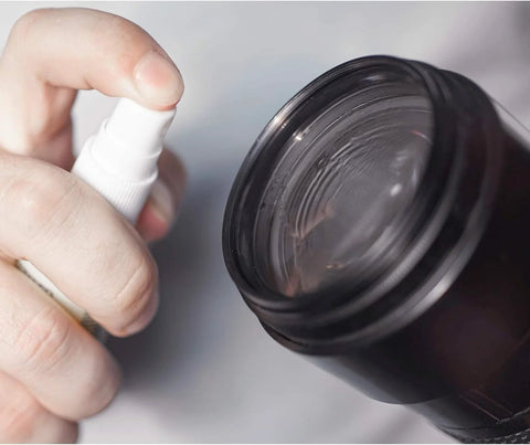 OptiSource Clear View lens cleaner spray bottle; close-up of white nozzle at dark bottle neck