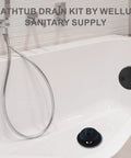 Bathroom showing installed Matte Black Lift And Turn Tub Drain Conversion Kit with two hole overflow faceplate.