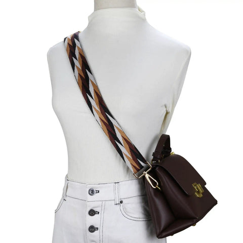 Wide Adjustable Jacquard Purse Strap For Women With Gold Hardware Thick Woven Crossbody Bag Replacement Strap In Leaf Brown Straight Fire Everyday Essential worn over a white top with a brown handbag.