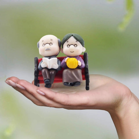 Mini Park Bench Grandpa And Grandma Figurines For Bonsai Garden And Fairy Garden Decor. Tiny plastic ornaments held in hand.