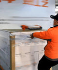 Worker using a Manual Stretch Film Dispenser That Makes Wrapping A Breeze With Adjustable Torque Clamps For Easy Pallet Wrapping