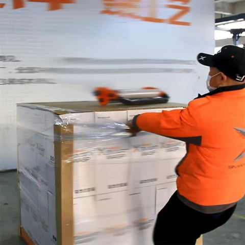 Worker using a Manual Stretch Film Dispenser That Makes Wrapping A Breeze With Adjustable Torque Clamps For Easy Pallet Wrapping
