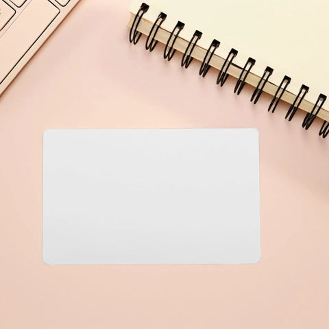 Twenty Piece Bundle Of Slick Blank White Pvc Id Cards With Heavy Duty Waterproof Coating And Hassle Free Printing For Quick Employee Badges And Double Sided Photo Cards In Sharp Resolution on a pink desk.
