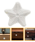 Front view of star shaped ceramic cabinet pull handle white knob for wardrobe and dresser drawers smooth ergonomic grip vintage style drawer pull for kitchen and furniture.