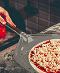 Person using Perforated 12 Inch Pizza Peel, Metal Pizza Turner For All Ovens, Indoor Outdoor Use, Lightweight And Durable Anodized Aluminum