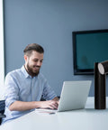 Lit LED Desk Lamp With Dimmable Brightness And 180 Degree Rotating Head next to man working on laptop in office setting