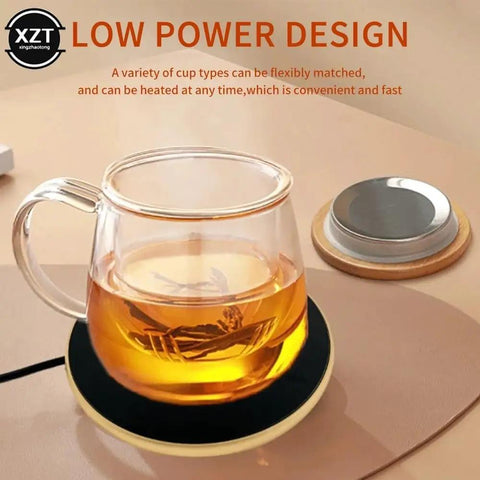 Badass Portable Cup Warmer And Coffee Mug Heating Coaster Offering Smart Thermostatic Temperature Control For Hot Milk Tea Or Water next to clear glass cup with tea on a circular warming pad.