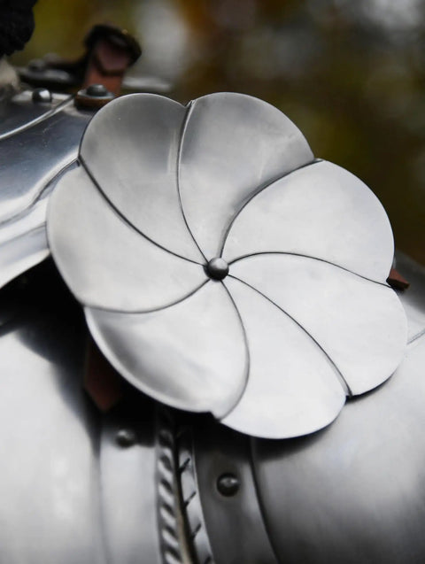 Close-up of Steel Rondels Besagews For Medieval Armor 14 cm round disc with brown leather straps, flower-shaped design.