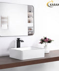 White Rectangle Vessel Sink For Bathroom Above Counter Porcelain Ceramic Basin With Black Rim Edge Modern European Inspired Design 18 Inch Exterior Sleek Small Sink Bowl For Bathrooms on wooden counter with mirror and flowers