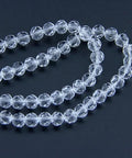 Premium 4Mm Clear 32 Faceted Glass Crystal Spacer Beads lying on a dark surface, showcasing multiple strands for DIY crafts.