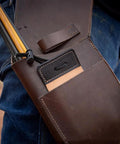 Square Cow Leather Archery Finger Tab For Right Hand Long Bow Hand Protector visible in brown leather pouch with arrows