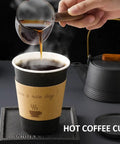 Pouring coffee into 100 Pack 12 Oz Thickened Coffee Cups With Lids Sleeves And Straws For To Go Coffee At Home Office Cafes And Parties Black 12 Oz Cups Bundle Perfect For Grab And Go Convenience.