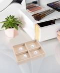 Beige Velvet Jewelry Display Tray With Four Grids And Sturdy Wooden Lid For Ring Bracelet Earring Storage Stackable Vanity Organizer on a vanity.