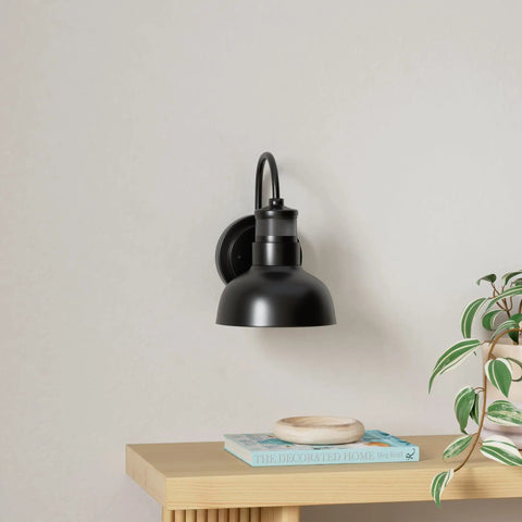 Black metal outdoor wall sconce on table, part of Six Pack Outdoor Wall Lights With GFCI Outlet Dope Dusk To Dawn Waterproof Exterior Sconce.