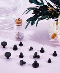 Cool 50 Pack Black Silicone Hole Plugs In 5 Sizes For Pipe And Bottle Ends Waterproof Flexible Rubber Stoppers That Fit Tight Without Leaking Any Liquid Or Mess Up Your Daily DIY Hacks At Home. Black silicone hole plugs in assorted sizes on a pink surface